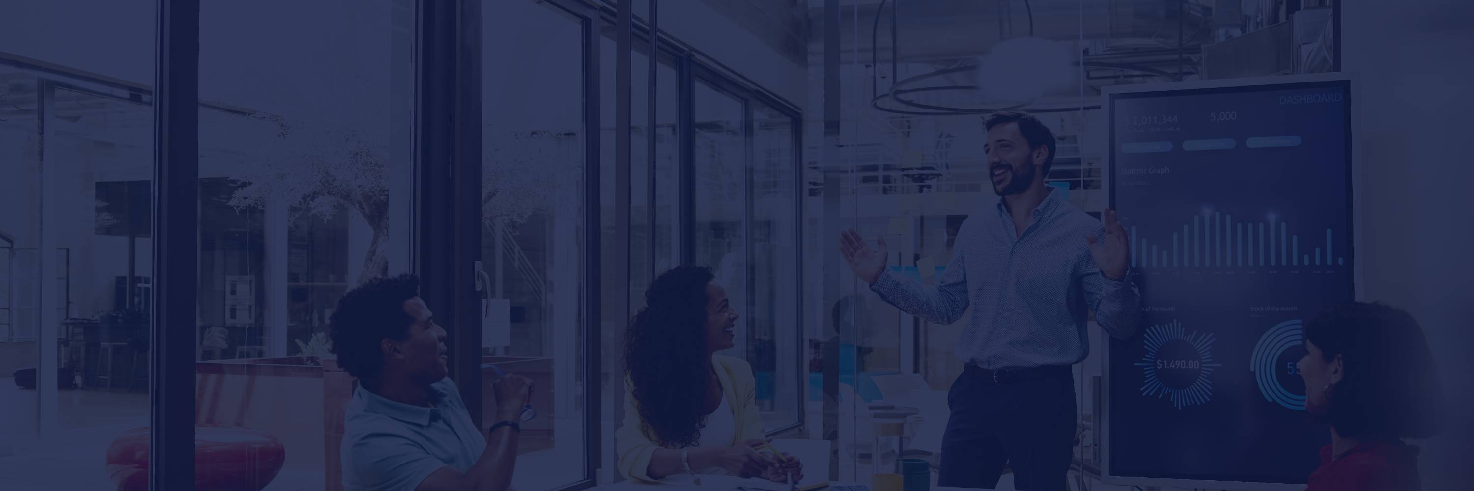 people in a meeting, with a man explaining graphs