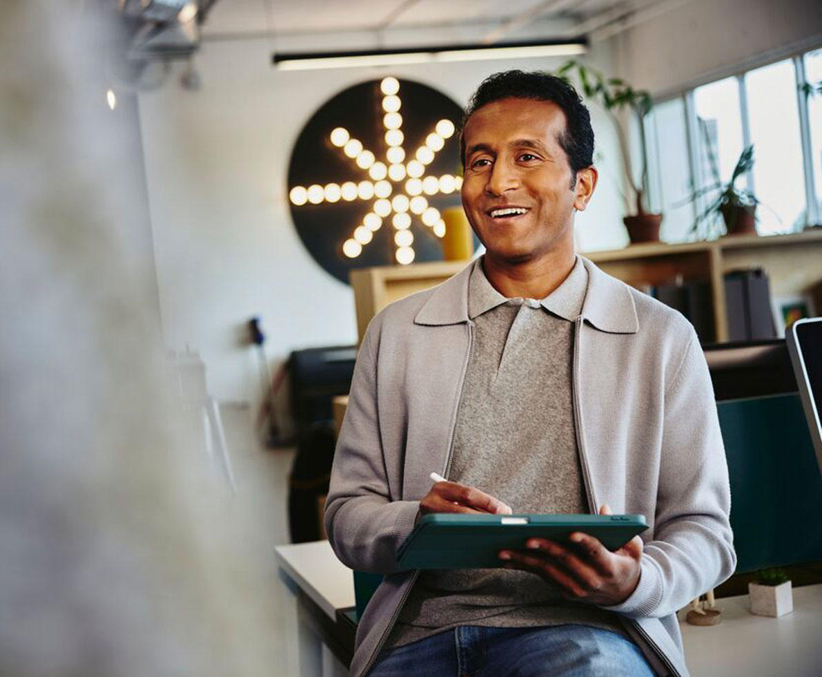 Male looking at a tablet in his hands holding a touch pen
